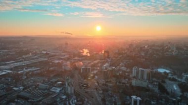 Chisinau 'nun güneş doğarken hava aracı görüntüsü. Birden fazla binanın manzarası, hareket eden arabaları ve çıplak ağaçları olan yollar. Yerde kar varken hava güzel. Moldova