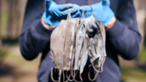 Hombre Con Guantes Médicos Sosteniendo Montón Máscaras Médicas Sucias Levantadas — Vídeo de stock