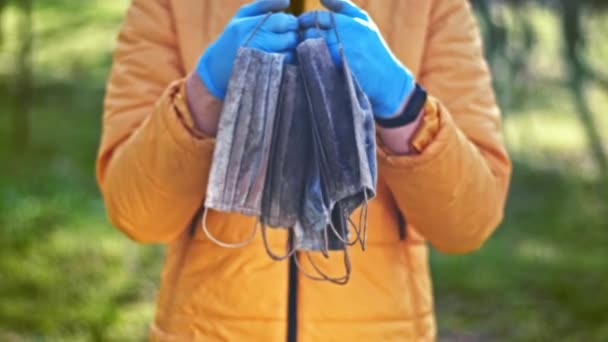 Man Medical Gloves Holding Bunch Dirty Medical Masks Raised Ground — Stock Video