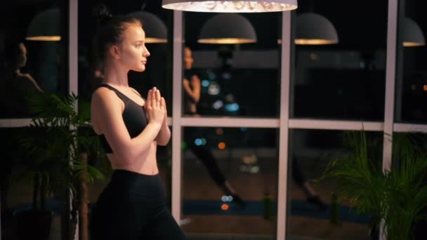 Mujer Joven Estirando Las Manos Mientras Hace Yoga Entrenamiento Interior — Vídeo de stock
