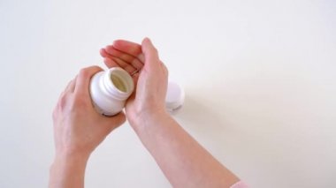 Kadın eli iki şişeden vitamin alıyor ve sonra kapatıyor. Sağlıklı yaşam tarzı fikri. Karantina