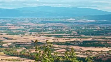 Yunanistan 'ın doğal manzarası, yeşillikli tarlalar, uzaktan görülebilen yeşil tepeler, bulutlu hava