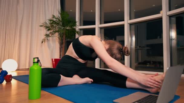 Giovane Donna Che Allunga Mentre Yoga Sto Guardando Portatile Allenamento — Video Stock