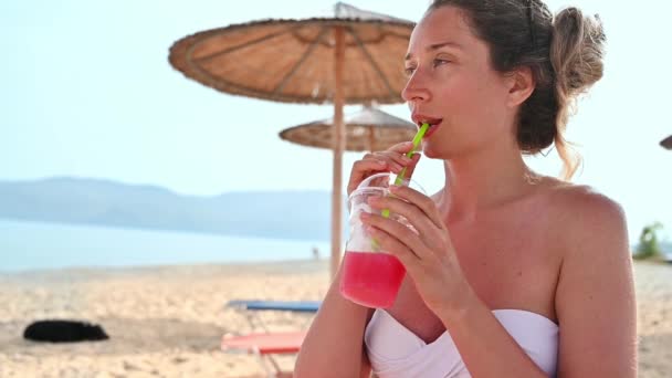 Femme Caucasienne Buvant Cocktail Rouge Sur Plage Mer Parapluies Mouvement — Video