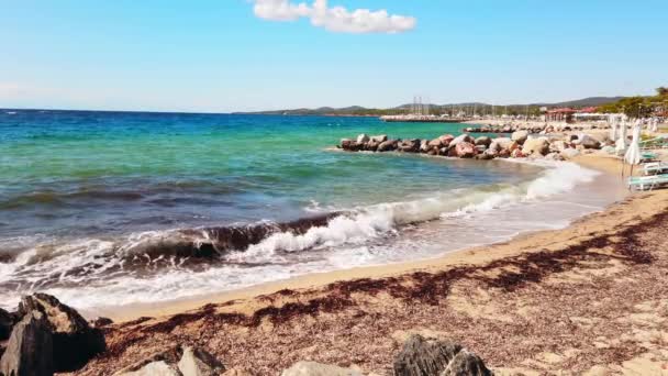 Strand Der Ägäisküste Mit Geschlossenen Sonnenschirmen Und Liegestühlen Felsen Wasser — Stockvideo