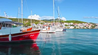 NEOS MARMARMARAS, GREECE - 8 Ekim 2020: Birden fazla demirlemiş yat ve teknesi olan Ege limanı, yeşillik ve açık hava olan bir tepenin üzerinde yer alan kasaba