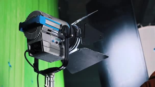 プレートを回転させる男と映画セット上のプロの照明器具 — ストック動画