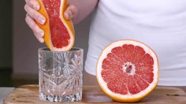 Žena Vymačká Šťávu Grapefruitu Sklenice Dřevěné Desce Zpomalený Pohyb — Stock video