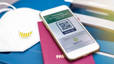 Uluslararası Aşı Sertifikası COVID-19 QR kodlu pasaport ve akıllı telefon.