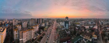 Chisinau, Moldova 'da güneş batarken hava aracı manzarası. Birden fazla konut ve ticari bina, birden fazla arabası olan yollar, çıplak ağaçlar, kış