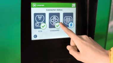 CHISINAU, MOLDOVA - 26 Nisan 2021: Elektro arabanın şarj göstergesi ve erkek eli