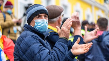 CHISINAU, MOLDOVA - 28 Nisan 2021: Sağlık maskeli adam, Anayasa Mahkemesi binası önünde erken seçimleri protesto eden insanlar