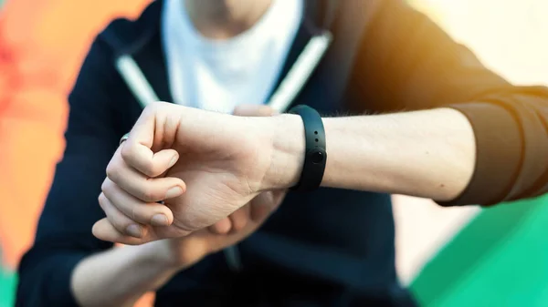 Joven Caucásico Hombre Está Pulsera Fitness Sobre Fondo Multicolor — Foto de Stock