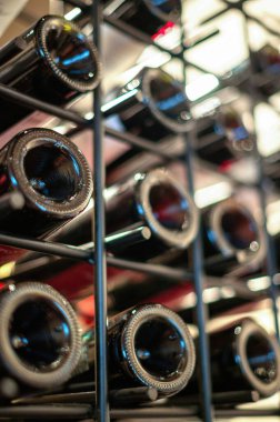 Şaraphanedeki şarap şişeleriyle dolu raflar.