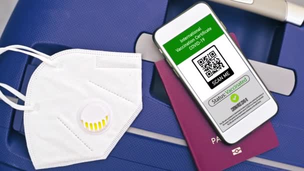 带有国际疫苗接种证书的护照和智能手机带有口罩的手提箱上的Covid Qr代码 — 图库视频影像