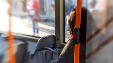 Pencerenin yanında bir tramvayda oturan bir kadın. Lensbaby artistik bulanıklık