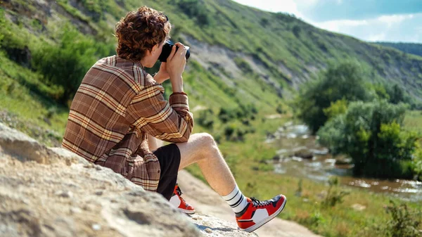 Jovem Com Cabelos Encaracolados Tirando Fotos Usando Câmera Natureza Sentado — Fotografia de Stock