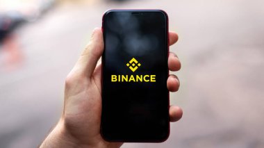 CHISINAU, MOLDOVA - 19 Haziran 2021: Ekranda Binance uygulamalı akıllı telefonu tutan adam