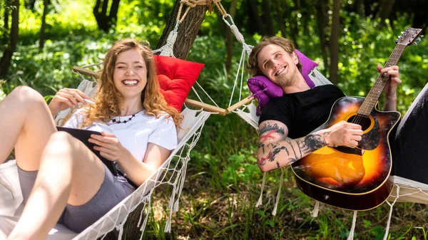 Casal Deitado Redes Jovem Está Tocando Guitarra Enquanto Mulher Está — Fotografia de Stock