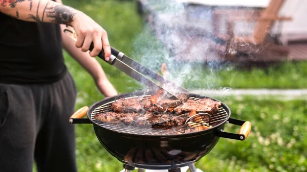 Mladý Muž Smaží Maso Grilu Zeleň Glamping — Stock fotografie