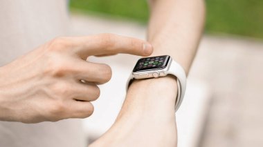 CHISINAU, MOLDOVA - 5 AĞUSTOS 2021: Apple Watch kullanan genç bir adam. Bir uygulama seçiliyor