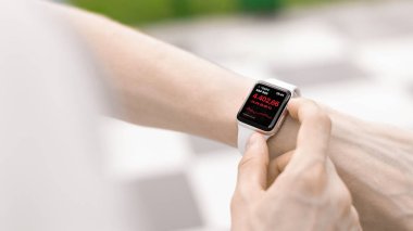 CHISINAU, MOLDOVA - 5 AĞUSTOS 2021: Apple Watch kullanan genç bir adam. Hisse fiyatları kontrol ediliyor