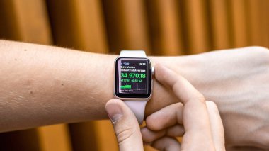 CHISINAU, MOLDOVA - 5 AĞUSTOS 2021: Apple Watch 'ta hisse fiyatlarını kontrol eden genç bir adam