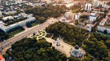 Chisinau şehir merkezindeki hava aracı görüntüsü. Birden fazla binanın panorama manzarası, hükümet, katedralli Central Park, hareket eden arabalı yollar. Gün batımı. Moldova
