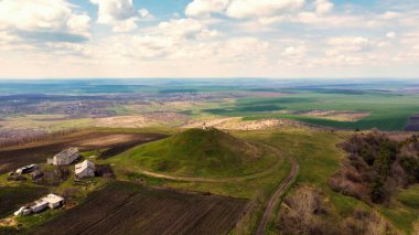 Moldova 'nın tepesinde haç olan bir tümseğin hava aracı görüntüsü. Uzakta tarlalar ve köyler