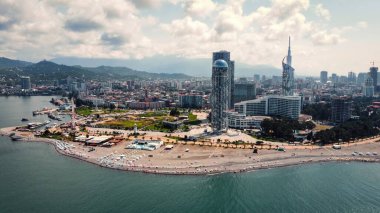 Georgia, Batumi 'deki sahil şeridinin insansız hava aracı görüntüsü. Karadeniz sahili, binalar, modern oteller ve deniz limanı, yeşillik ve dağlar