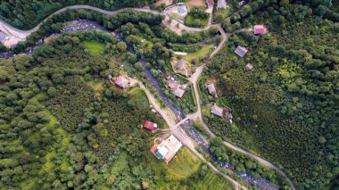 Georgia 'daki doğanın insansız hava aracı görüntüsü. Dar nehir ve köylü vadi, yeşil yamaçlarla kaplı tepeler, dikey manzara