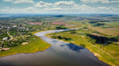 Moldova 'daki doğanın insansız hava aracı görüntüsü. Köy, yüzen nehir, köprü, tarla, yeşillik