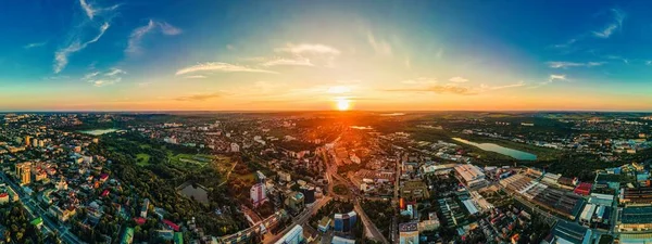 Aerial drone view of Chisinau downtown. Panorama view of multiple buildings, roads. Parks with lush greenery and lakes. Sunset. Moldova