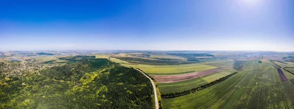 Aerial drone panorama view of nature in Moldova. Highway, wide fields, village, forest