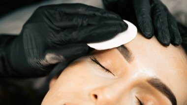 Makyaj ustası müşteri için kalıcı kaş makyajı prosedürünü gerçekleştirir