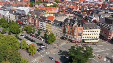 Kopenhag, Danimarka - 6 Ağustos 2025: Araba ve bisikletçilerle dolu modern yolların yanında tarihi tuğla binaların insansız hava aracı görüntüsü
