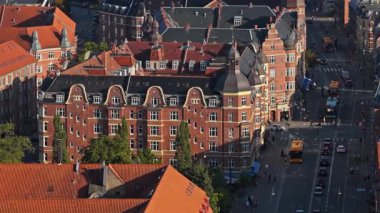 Osterbro bölgesindeki turuncu çatıları ve hareketli caddeleri olan tarihi kırmızı tuğlalı binaların insansız hava aracı görüntüsü.