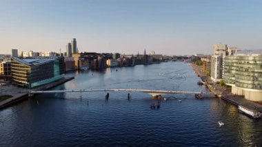 Kopenhag, Danimarka - 6 Ağustos 2025: İç Liman ve Langebro Köprüsü 'nün hava aracı görüntüsü botlar, bisikletçiler ve günbatımında modern şehir silüeti