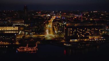 Brygge Adaları ve Kopenhag 'ın iç limanının deniz üzerindeki renkli yansımaları ve geceleyin Danimarka' daki Tivoli Bahçeleri 'nin hava aracı görüntüsü.