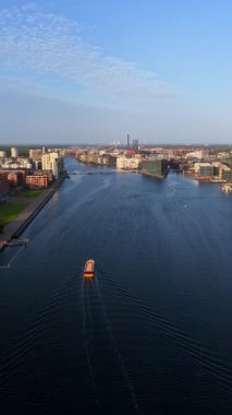 Danimarka 'nın Kopenhag limanındaki tekneler ve modern binalarla Nyhavn Kanalı' nın ve şehir manzarasının insansız hava aracı görüntüsü. Dikey
