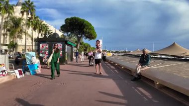 Cannes, Fransa - 20 Eylül 2025: Turistler, yerel sanatçılar ve deniz manzaralı ünlü Croisette gezinti alanı