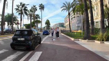 Cannes, Fransa - 20 Eylül 2025 Croisette Bulvarı Palmiye ağaçları ve lüks otellerle ünlü sahil şeridi boyunca yürüyen insanlar