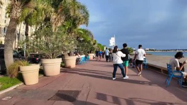 Cannes, Fransa - 20 Eylül 2025 Croisette Bulvarı Palmiye ağaçları ve lüks otellerle ünlü sahil şeridi boyunca yürüyen insanlar