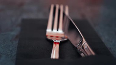 Lokantadaki siyah bir peçeteye yerleştirilmiş gümüş çatal bıçak takımını kapat.