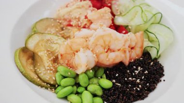 Domatesli, kinoalı, edamame ve kabaklı sağlıklı karides kasesi.