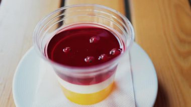 Parlak katmanlı jöle tatlısını ahşap bir masada temiz bir fincanda kapat.