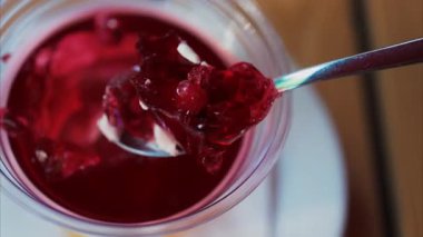 Bir kaşığı kapat ve canlı kırmızı jöle tatlısına kır.