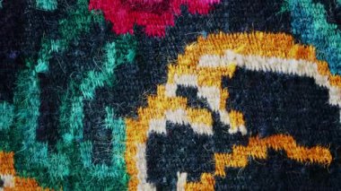 Canlı renkler ve karmaşık detaylarla geleneksel bir çiçek halısını kapatın.