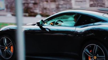 Chisinau, Moldova - 25 Eylül 2025: Lüks siyah Ferrari spor arabası şehir sokaklarında ilerliyor
