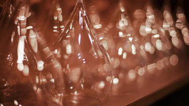 Arka planda altın bir bokeh etkisi yaratan sıcak ışıkla hafifçe aydınlatılmış çoklu cam damarların yakın görüntüsü